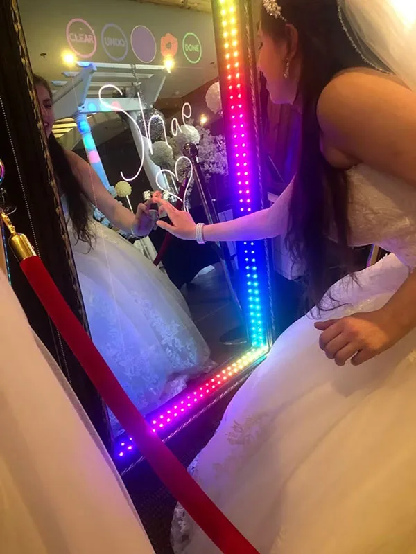 Brides signing the Adirondack Selfie Mirror together