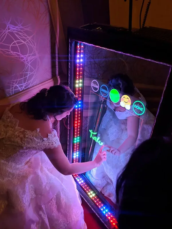 Bride writing on the Adirondack Selfie Mirror at a wedding reception